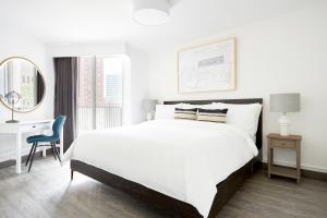a white bedroom with a large bed and a desk at Sonder at The Terrace in Philadelphia