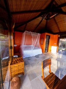 Zimmer mit einem Bett, einem Tisch und einem Stuhl in der Unterkunft Alizées Moreré in Ilha de Boipeba
