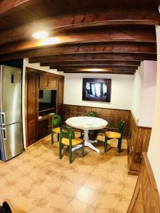 a kitchen with a table and chairs and a refrigerator at Casa Bernardita in Colunga
