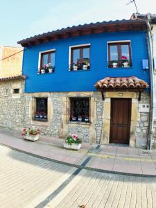 a blue building with flowerpots in front of it at Casa Bernardita in Colunga