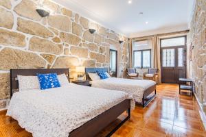 a bedroom with two beds and a stone wall at Riverside City Centre Apartments in Porto