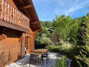 a patio with a wooden table and chairs on a house at Chalet Van Gogh in Morillon