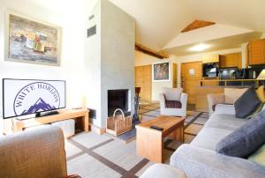 a living room with two couches and a fireplace at Exceptional 3 bed Penthouse with fireplace and stunning views in Flaine