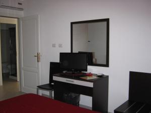 a room with a desk with a television and a mirror at La Rosa Affittacamere in La Caletta