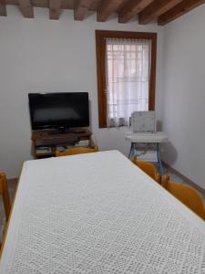 una camera con tavolo bianco e televisore di come a casa tua dietro piazza San Marco a Venezia