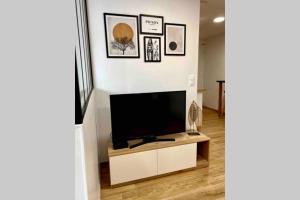 a living room with a flat screen tv on a white wall at Studio moderne au cœur de Reims in Reims