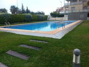 a swimming pool in a yard next to a building at Oliva Nova in Oliva