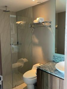 a bathroom with a toilet and a glass shower at Hermosa Playa en Acapulco Diamante, Isla Residence in Acapulco