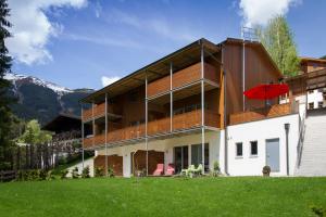 ein großes Gebäude mit einem roten Regenschirm im Hof in der Unterkunft Steinbock Superior Appartement in Zell am See