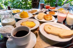 a table with plates of breakfast food and a cup of coffee at Alizées Moreré in Ilha de Boipeba
