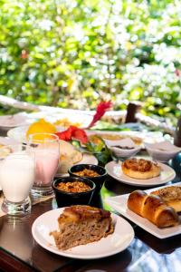 una mesa con platos de comida y vasos de leche en Alizées Moreré, en Isla de Boipeba