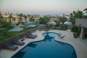 vistas a una piscina con sillas y sombrillas en Casa Lulú en San José del Cabo