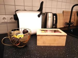 een aanrecht met een koffiepot en een mand met borden bij Ruhiges Hinterhof Apartment im Herzen der Neustadt in Dresden
