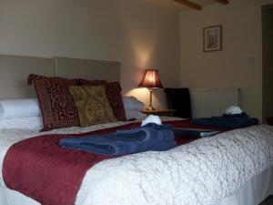 a bedroom with two beds with blue towels on them at Middle Woodbatch B&B in Bishops Castle