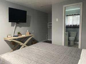 a bedroom with a bed and a television on the wall at Superlodge in Dover