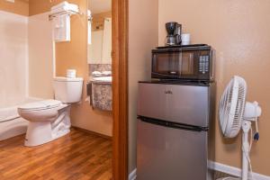 a bathroom with a microwave on top of a refrigerator at Far West Motel in Forks