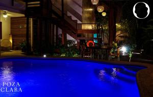 a blue swimming pool at night with a table at Poza Clara Sanctuary in Bacalar