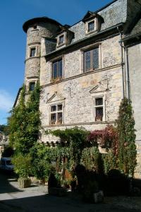 a large stone building with windows and plants at Village de Gite - La Cascade in Sainte-Eulalie-dʼOlt