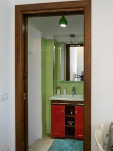 baño con lavabo rojo y espejo en Casa Marietta, en San Nico