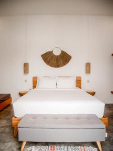 1 dormitorio con cama blanca y sofá en Betah Homestay Banyuwangi, en Banyuwangi