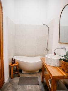 y baño con bañera y lavamanos. en Betah Homestay Banyuwangi, en Banyuwangi