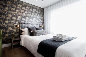 - une chambre dotée d'un lit avec du papier peint noir et or dans l'établissement Sunny Green Palms Micro Studio with Yard View by Den Stays, à Montréal