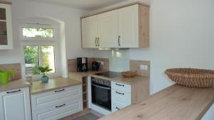 a kitchen with white cabinets and a wooden counter top at Ferienwohnung Am Ochsenweg in Hüsby
