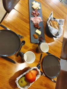 Amillano Rural Suites - Adults only في Amillano: طاولة مع طبق من الطعام واللحوم والجبن