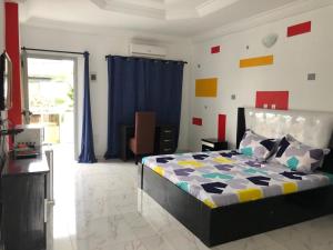 アビジャンにあるResidences Hotels Sejours Affairesのベッドルーム(ベッド1台、青いカーテン付)