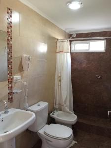Un baño con un inodoro blanco y un lavabo. en A metros de la Playa...., en Federación