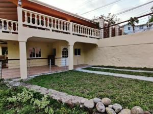 una casa grande con un patio delante en Sunny Acres Villa, St.Lucia, en Choc