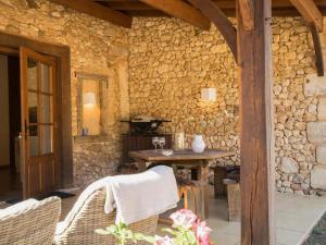 een stenen patio met een houten tafel en stoelen bij Gapard La Grange in Issac