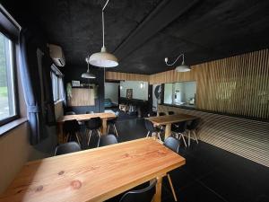 a dining room with wooden tables and chairs at Drifter Myoko in Myoko