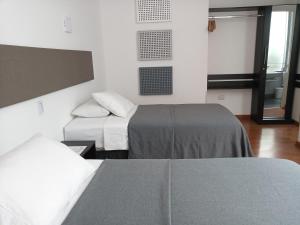 
a hotel room with two beds and a television at 3B Barranco's - Chic and Basic - B&B in Lima
