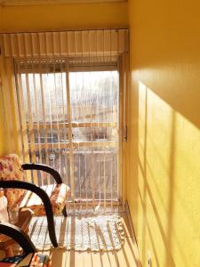 Habitación con ventana con persianas y silla en Sobrado Livramento Rivera Diaria, en Santana do Livramento