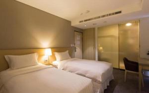een hotelkamer met twee bedden en een bureau bij 麗馨商旅七賢館 in Kaohsiung +84 foto's