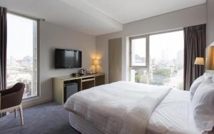 een hotelkamer met een bed en een flatscreen-tv bij 麗馨商旅七賢館 in Kaohsiung