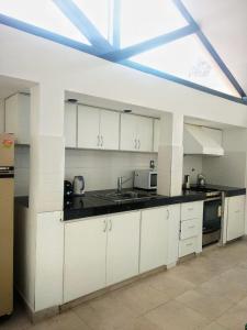a kitchen with white cabinets and a large window at El Mirador in Potrerillos