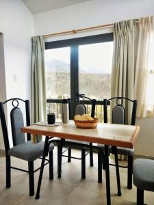 a dining room table and chairs with a large window at El Mirador in Potrerillos