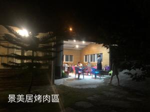 Xijing Ecological Farm في Hualing: رجل يقف أمام المنزل في الليل