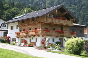 a house with a balcony with red flowers on it at Appartement Kichelerhof in Strass im Zillertal