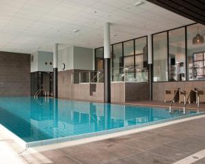 a swimming pool with a tub and a chair in it at Norefjell Ski & Spa in Noresund