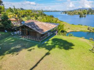 an overhead view of a house on a hill next to a lake at Loge Cabaña peñol-Guatape in El Peñol