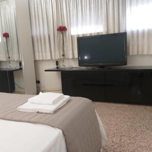 een hotelkamer met een televisie en een bed bij Locazione Turistica Gioia in Padua