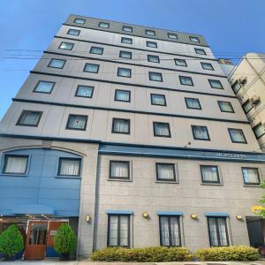 a tall gray building with windows on top of it at Hotel Morschein in Matsumoto