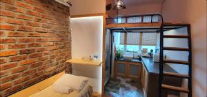 a room with a brick wall and a bunk bed at Tiny Home in Miri
