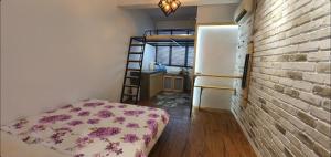 a room with a bed and a brick wall at Tiny Home in Miri