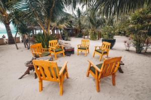 a group of wooden chairs and tables on the beach at Amihan Beach Cabanas in Bantayan Island