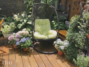 花蓮市にあるMoon House B&Bの花の咲くデッキに座る緑の椅子