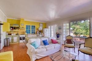 a living room with a white couch and a kitchen at Elegant House With Terrace Garden And Pool in Sanary-sur-Mer